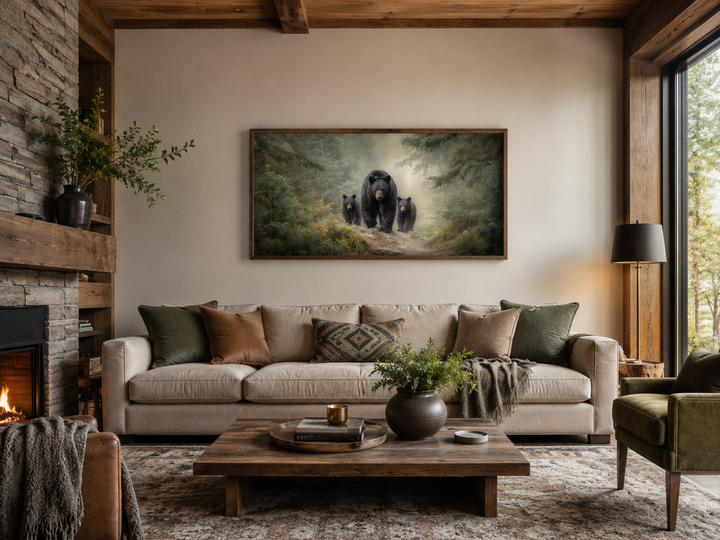 Mama bear and two cubs in a misty pine forest canvas wall art above a sofa in a rustic living room.