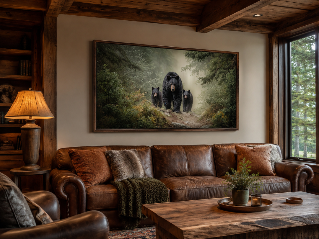Mama bear and two cubs in a misty pine forest canvas wall art hanging above a brown leather sofa.