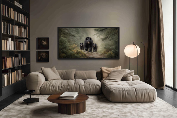 Mama bear and two cubs in a misty pine forest canvas wall art above a modern sofa in a living room.