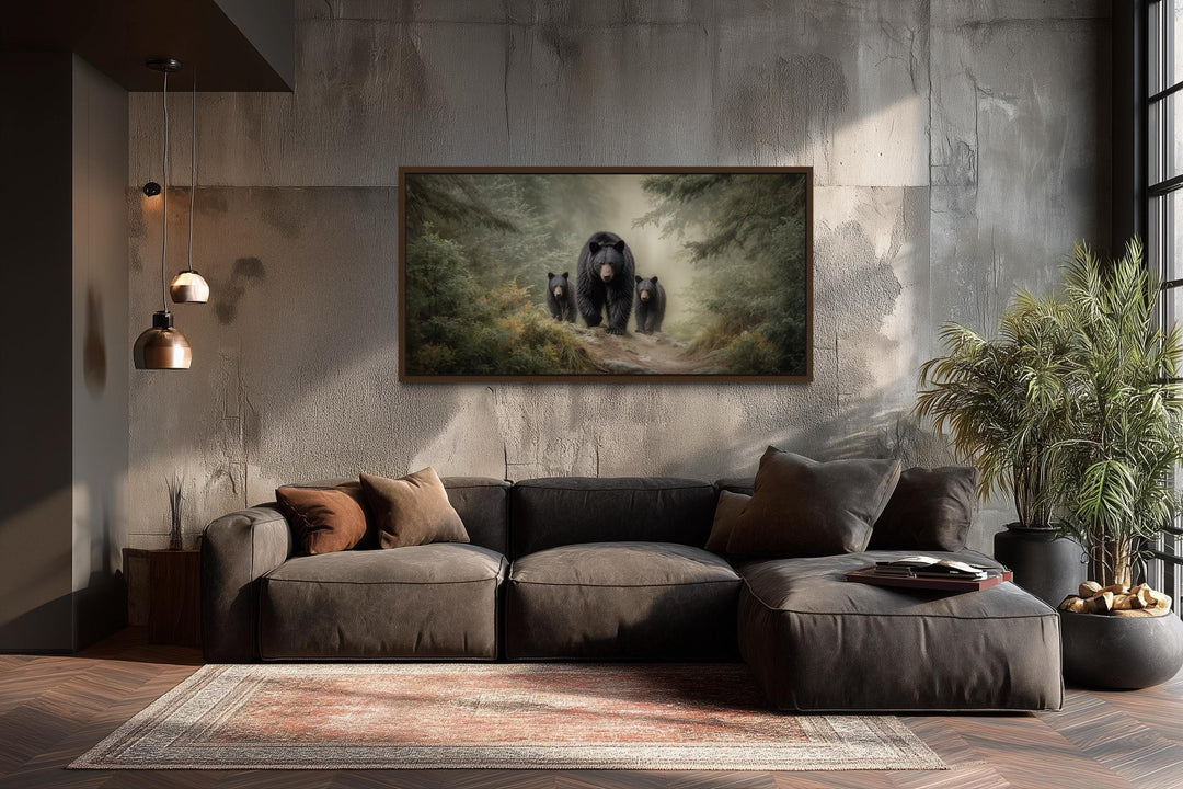 Mama bear and two cubs in a misty pine forest canvas wall art above a modern brown sectional sofa.