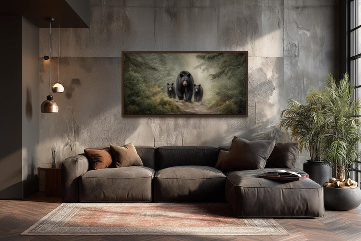 Mama bear and two cubs in a misty pine forest canvas wall art above a modern brown sectional sofa.
