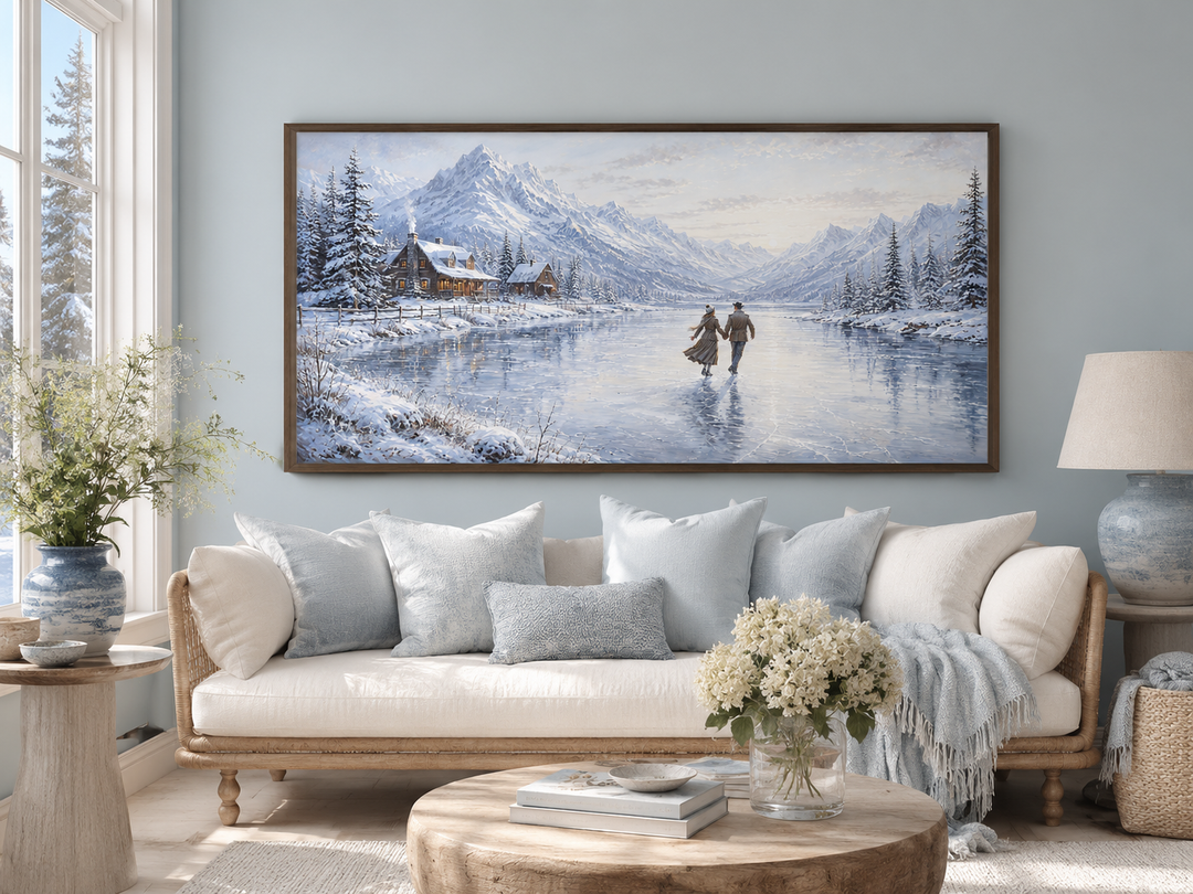 Framed canvas art of a man and woman skating on a frozen lake with snowy mountains and a cabin.