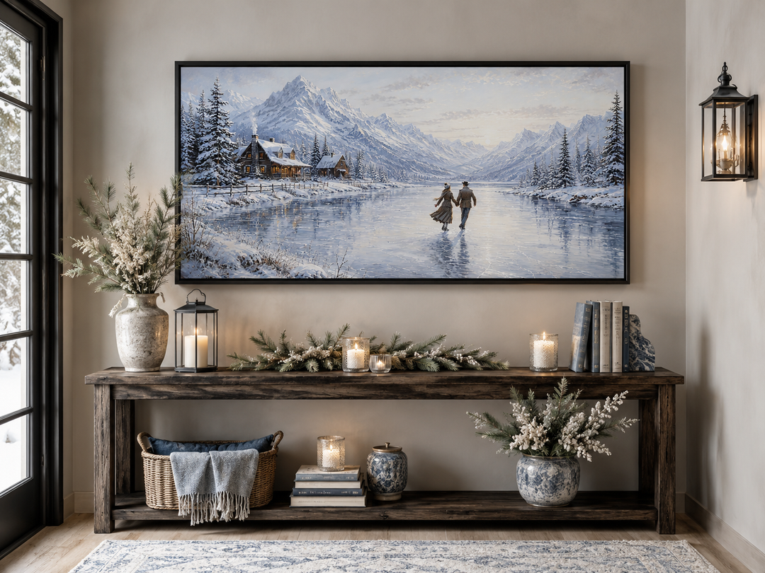 Framed canvas wall art of a couple skating on a frozen lake with snow-capped mountains and cabins.