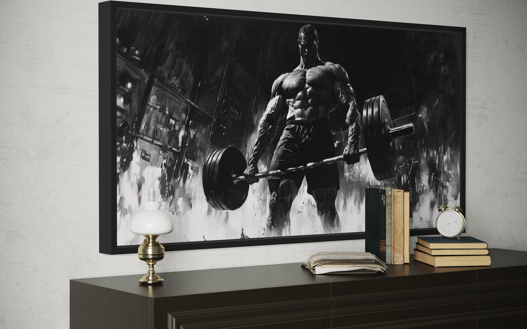 Man doing deadlift motivational gym framed canvas wall art in black and white on a dark dresser.