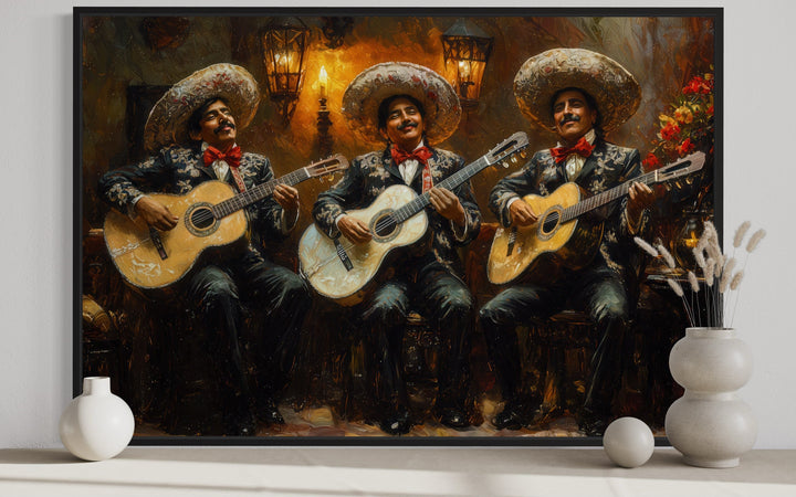 Framed canvas wall art of three mariachi musicians in traditional attire playing guitars.