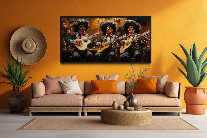 Framed extra large canvas print of a mariachi band on an orange wall above a tan sofa.