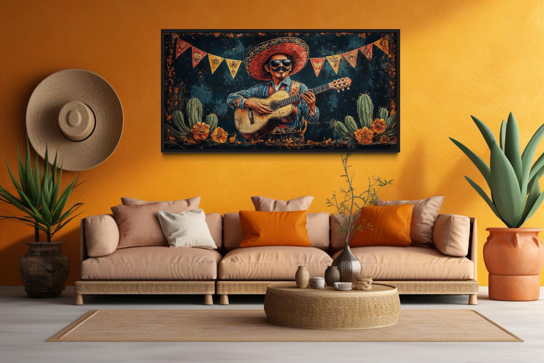Mariachi musician playing guitar in a desert scene framed canvas art on an orange living room wall.