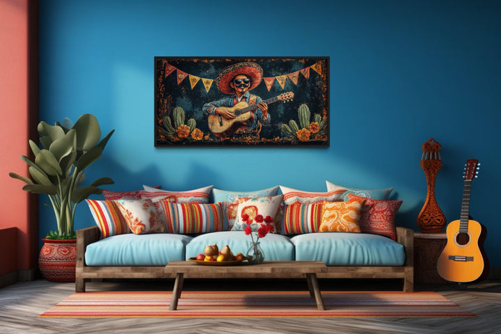 Mariachi musician in desert framed canvas wall art above a colorful sofa in a blue room.