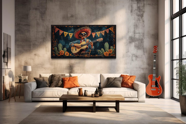 Framed canvas wall art of a mariachi musician playing guitar in a desert above a white sofa.