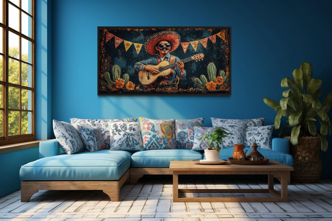 Mariachi musician in desert framed canvas wall art hanging above a blue sofa in a living room.