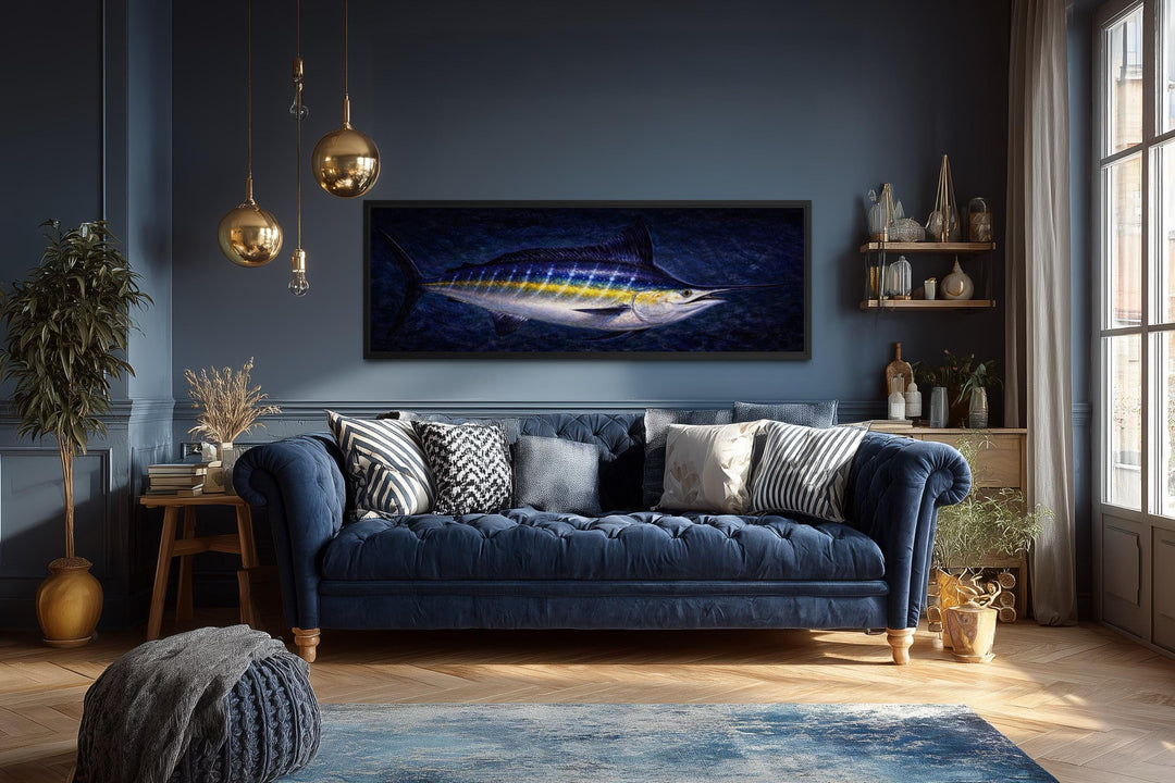 Long horizontal canvas print of a blue marlin fish over a sofa in a dark blue nautical room.