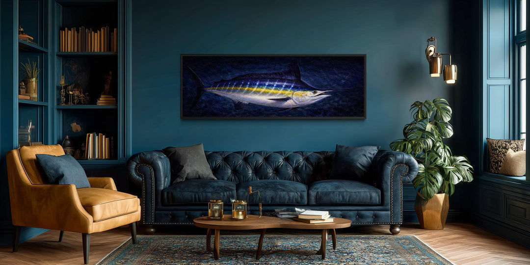 Long horizontal canvas print of a blue marlin swimming in a dark ocean, hung in a modern living room.