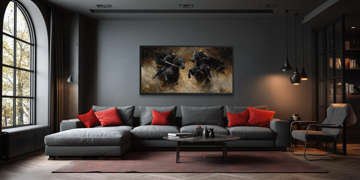 Horizontal framed canvas painting of two medieval knights dueling on horseback in a dark room.