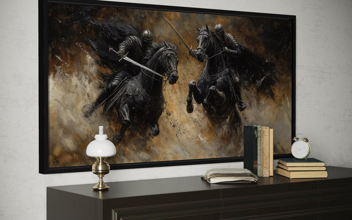 Horizontal framed canvas painting of two medieval knights in a dramatic duel on horseback.