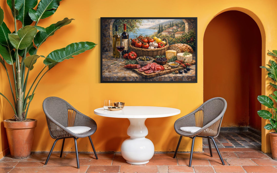 A framed Mediterranean still life canvas print hangs above a white table in a sun-drenched room.