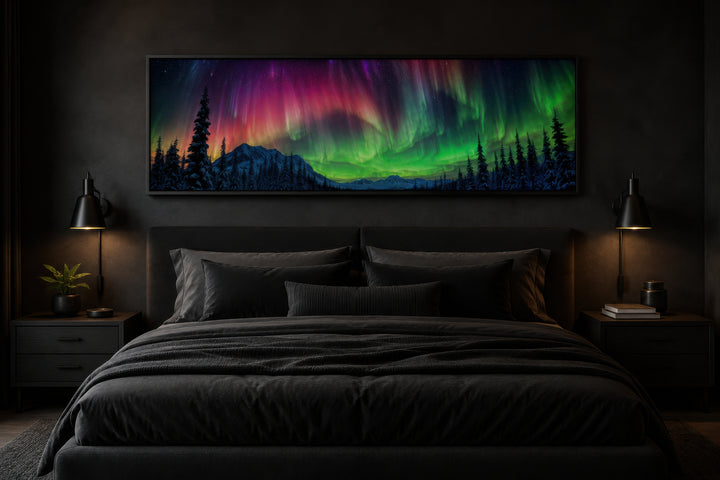 Panoramic framed canvas of the Aurora Borealis in pink and green above a dark modern bed.