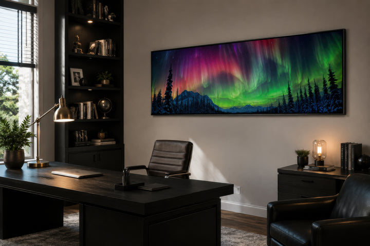 Long horizontal framed canvas wall art of the Aurora Borealis above a dark wood office desk.