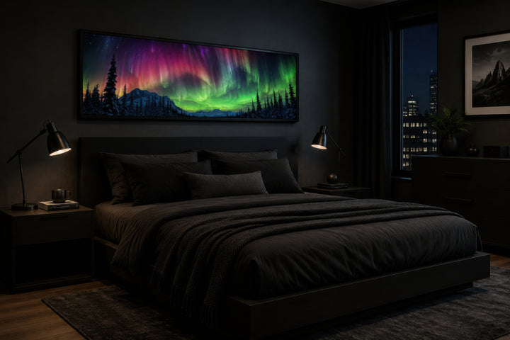 Long horizontal framed canvas of the Aurora Borealis above a bed in a dark, modern bedroom.