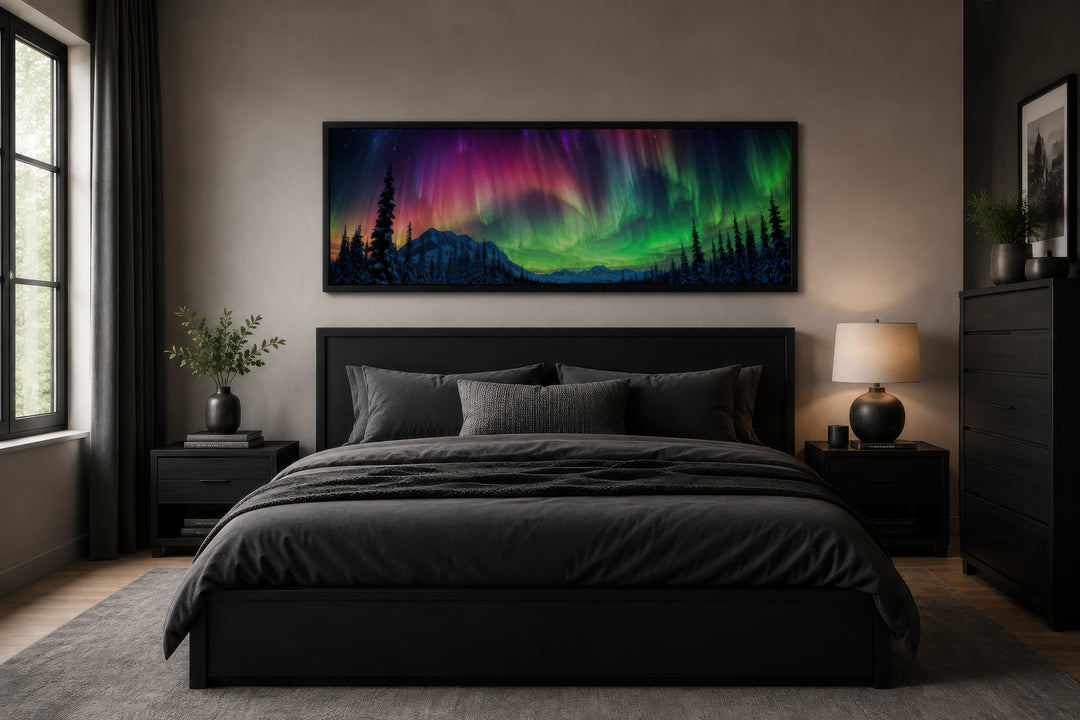 Horizontal framed canvas of the Aurora Borealis in pink and green above a dark modern bed.
