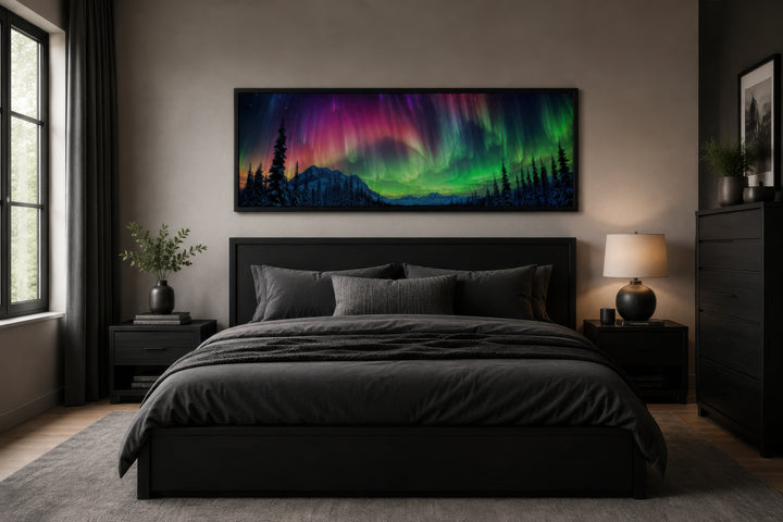 Horizontal framed canvas of the Aurora Borealis in pink and green above a dark modern bed.