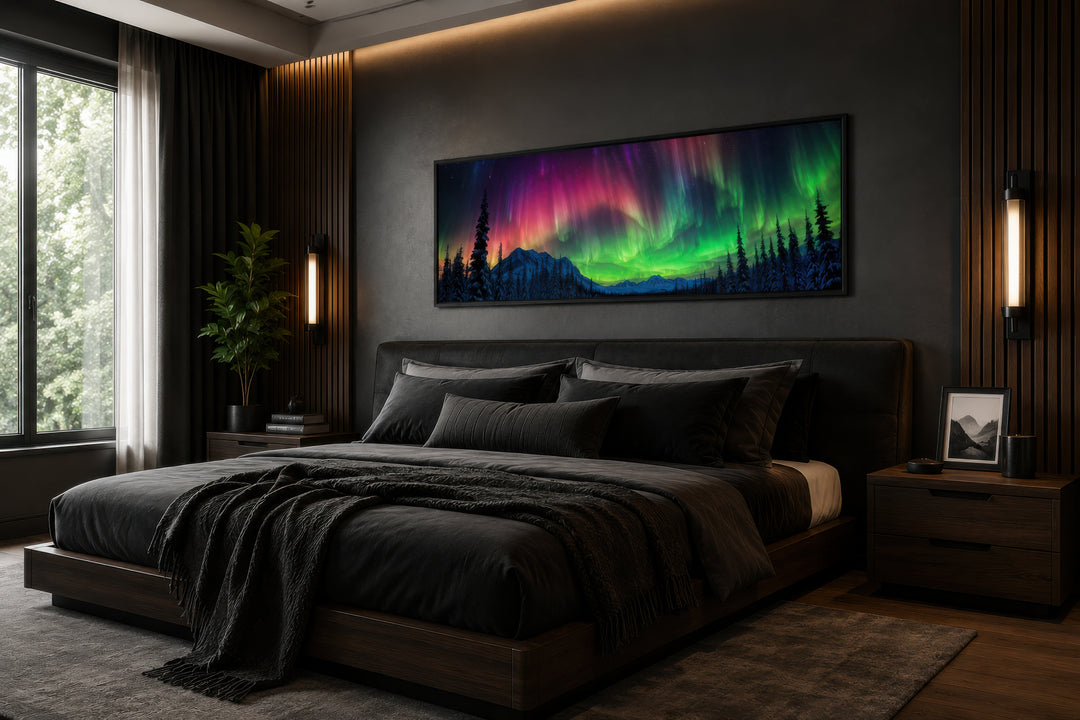 Horizontal framed canvas of the Aurora Borealis in pink and green above a dark modern bed.