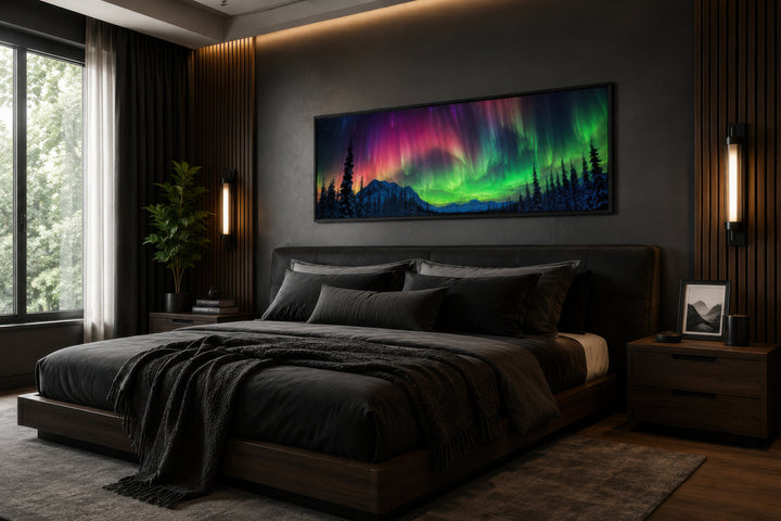 Horizontal framed canvas of the Aurora Borealis in pink and green above a dark modern bed.