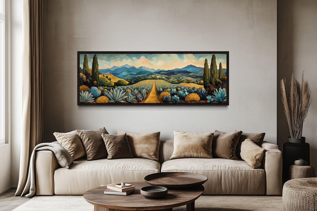 Panoramic canvas wall art of a Mexican agave field with mountains above a beige sofa.