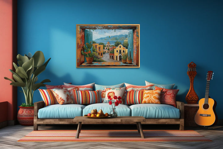 Mexican Village Window View Framed Canvas Wall Art above a blue sofa with colorful pillows.
