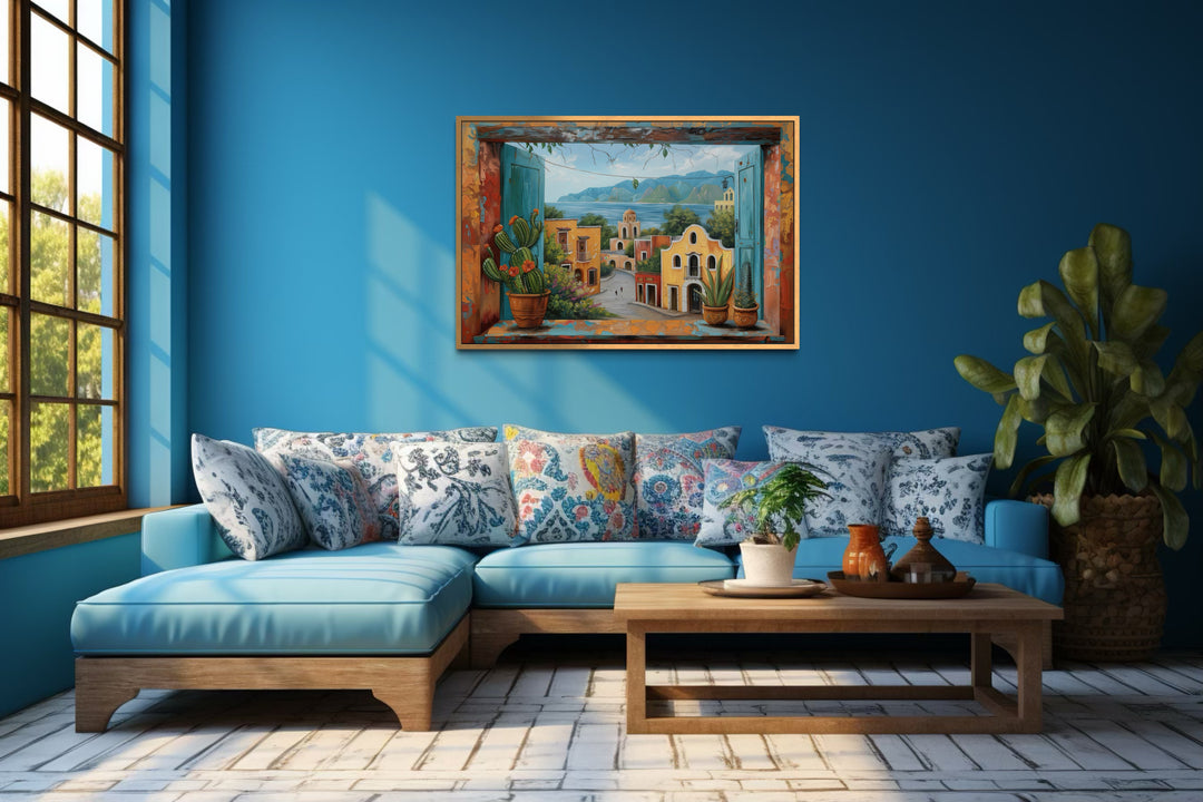 Mexican Village Window View Framed Canvas Wall Art hanging on a blue wall above a sofa.