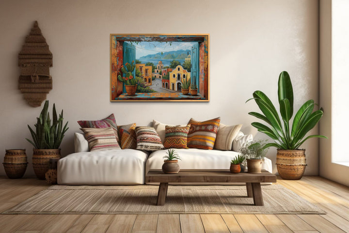 Mexican Village Window View Framed Canvas Wall Art hanging above a white sofa in a rustic room.