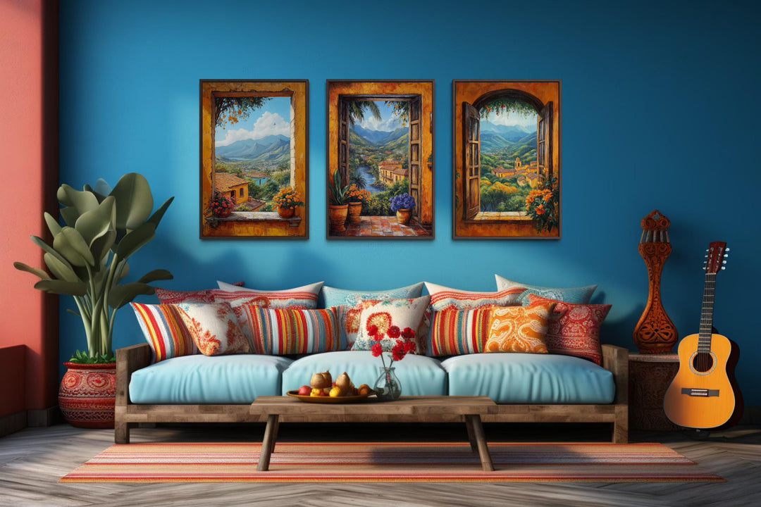 Set of three colorful canvas prints depicting scenic Mexican window views over a blue sofa.