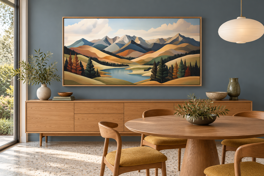 Mid-century modern mountain lake canvas print in a wooden frame above a sideboard in a dining room.
