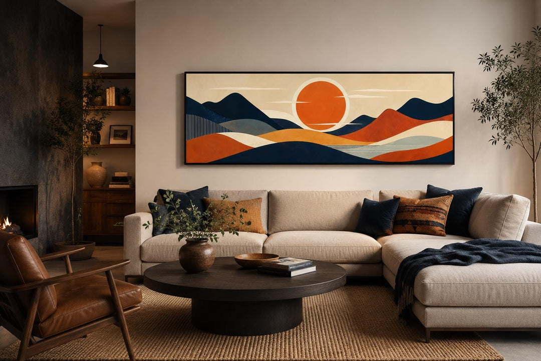 Mid-century modern navy and orange mountain sunset canvas print above a living room sofa.
