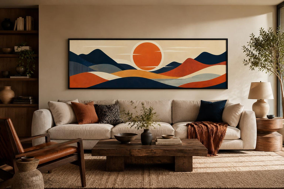 Mid Century Modern navy and orange mountain sunset canvas print above a beige sofa in a living room.
