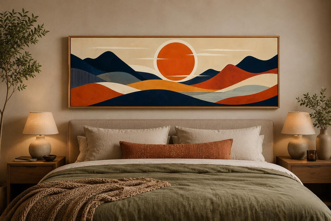 Mid-century modern navy and orange mountain sunset canvas print hanging above a bed.