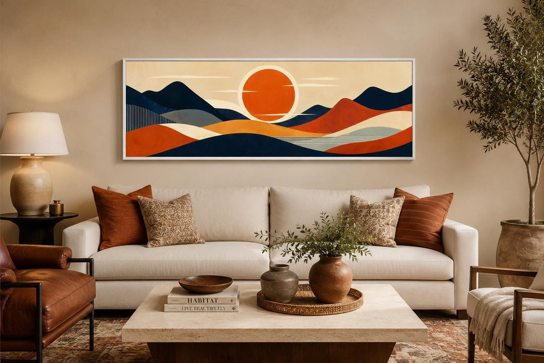 Mid-century modern navy and orange mountain sunset canvas print above a sofa in a living room.