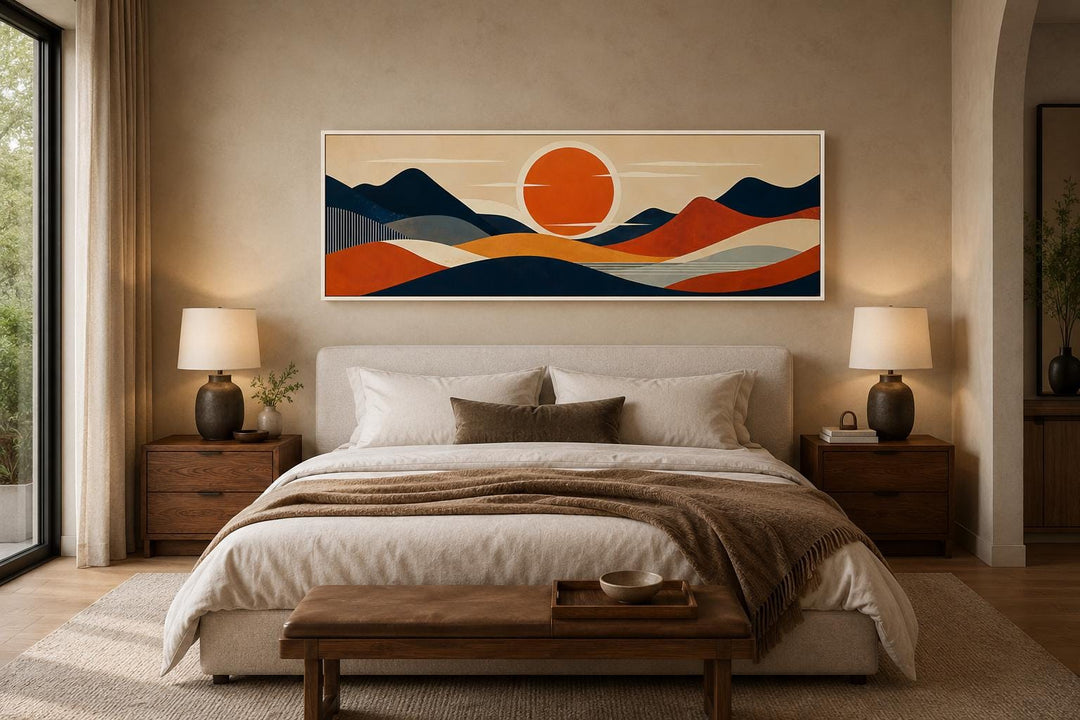 Mid-century modern navy and orange mountain sunset canvas print hanging above a bed.