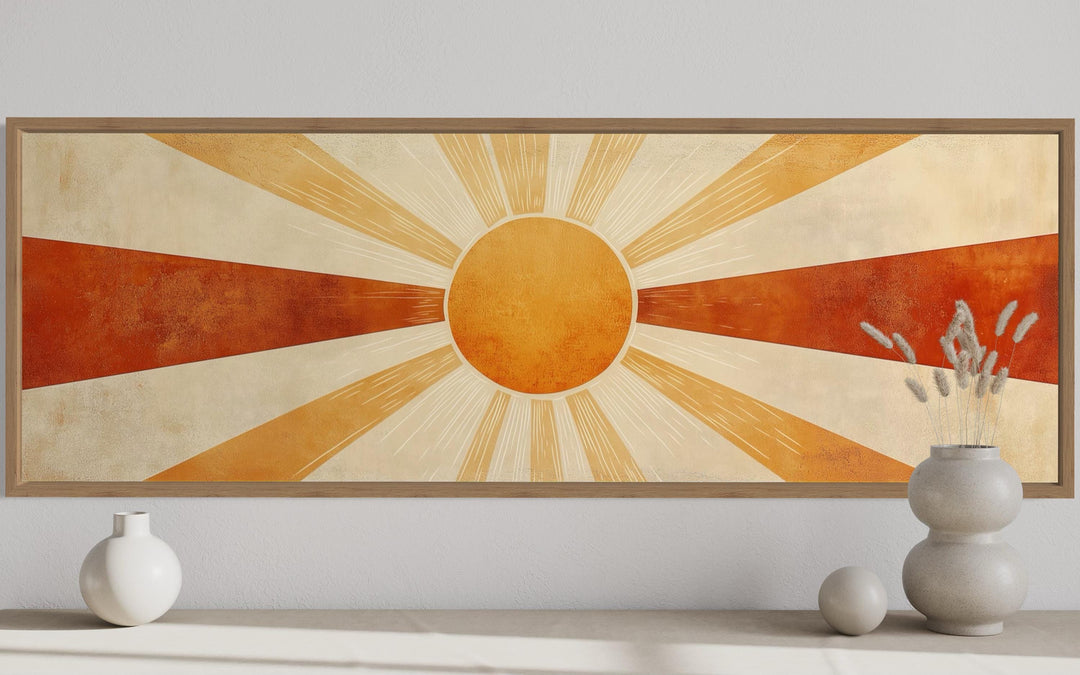 Mid-century modern sun rays wall art in orange, rust, and beige tones with a wooden frame.