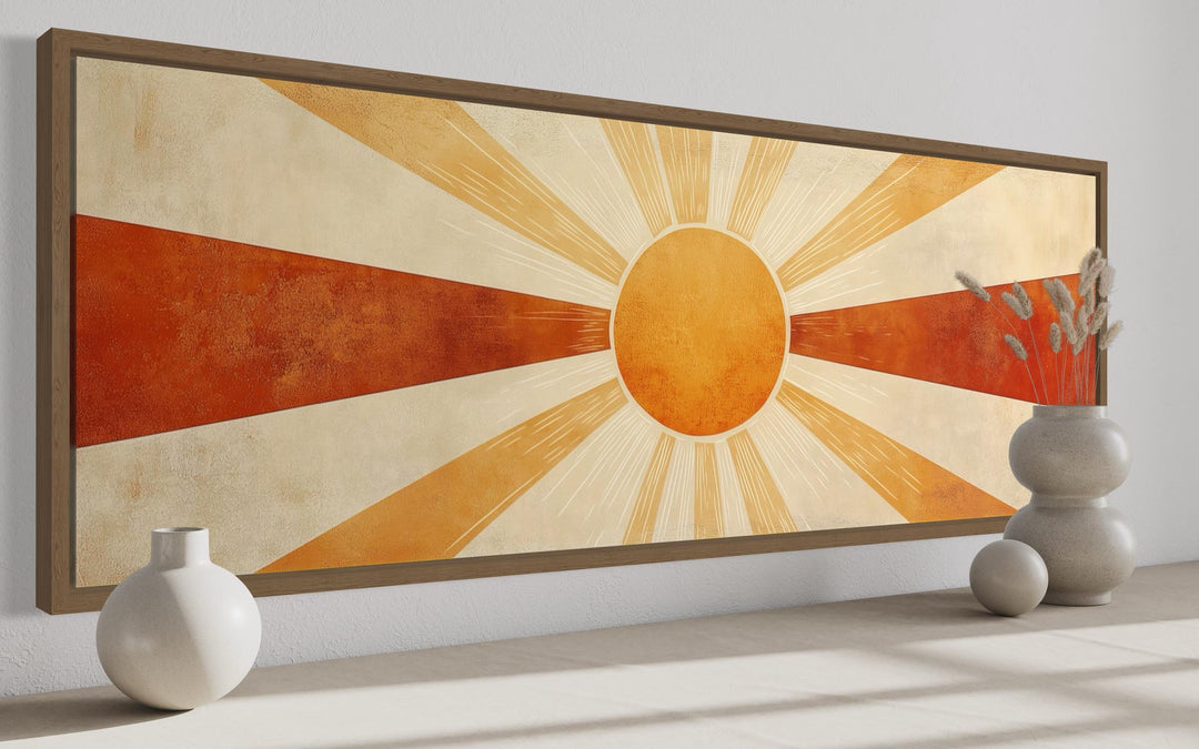Mid-century modern sun rays wall art in orange, rust, and beige tones with a wooden frame.