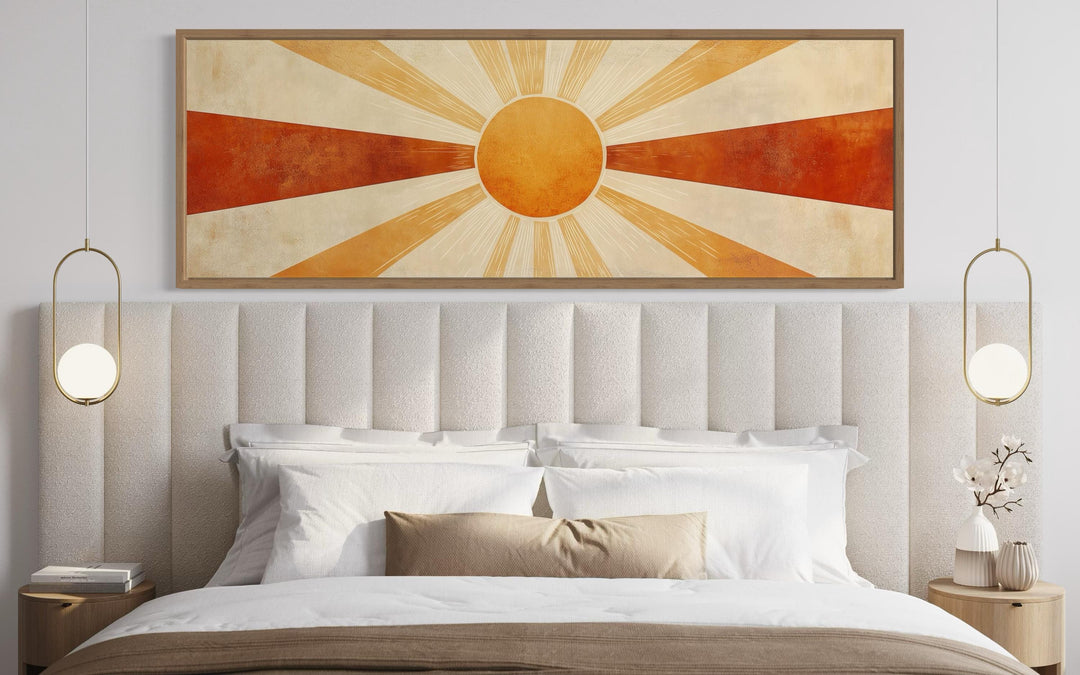 Mid-century modern sun rays horizontal wall art in warm orange and rust tones above a bed.