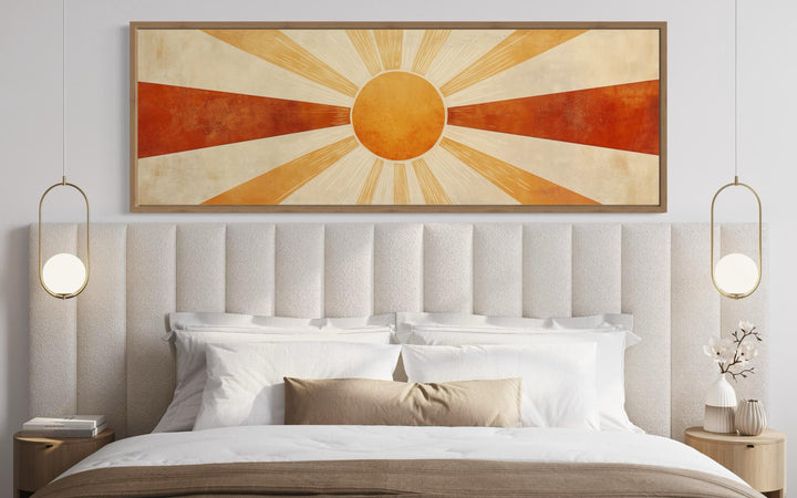 Mid-century modern sun rays horizontal wall art in warm orange and rust tones above a bed.