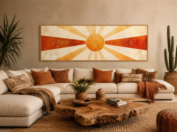 Mid-century modern sun rays wall art in a long horizontal frame above a neutral sectional sofa.