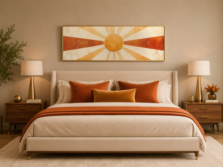 Mid-century modern sun rays long horizontal canvas wall art in a gold frame above a bed.