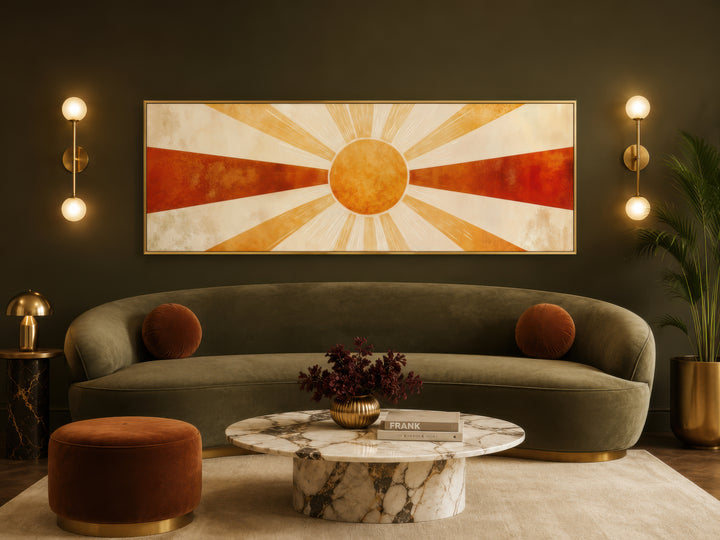 Mid century modern sun rays long horizontal wall art in a gold frame above a green velvet sofa.