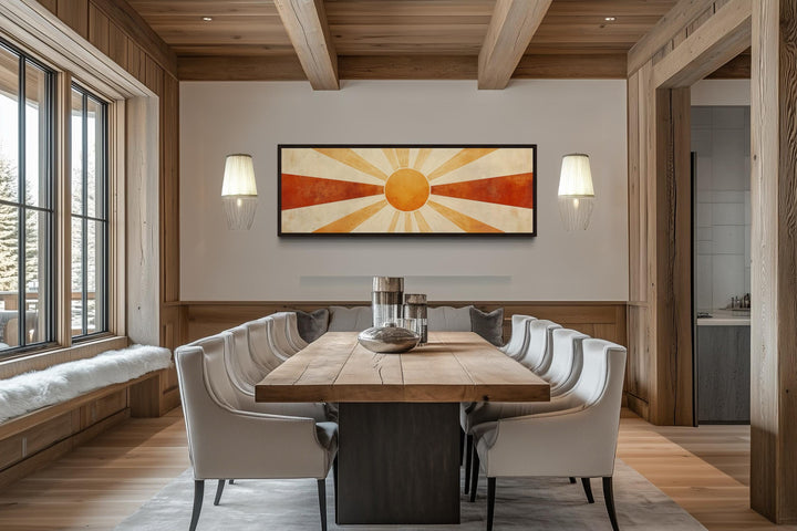 Mid century modern sun rays long horizontal wall art in a dining room with a large wooden table.