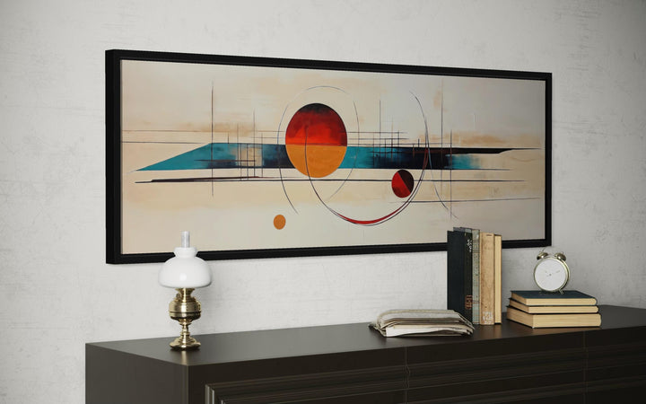 Mid century modern abstract canvas print with geometric shapes in a long horizontal black frame.