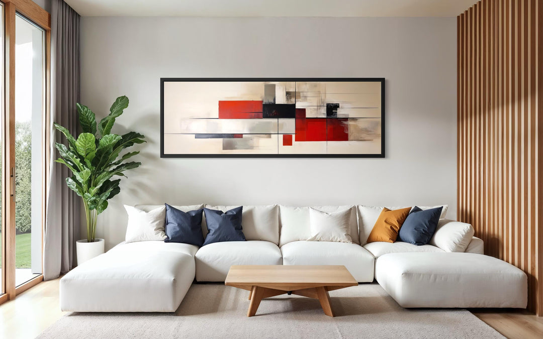 Large abstract geometric canvas print with red, beige, and black shapes in a black frame.