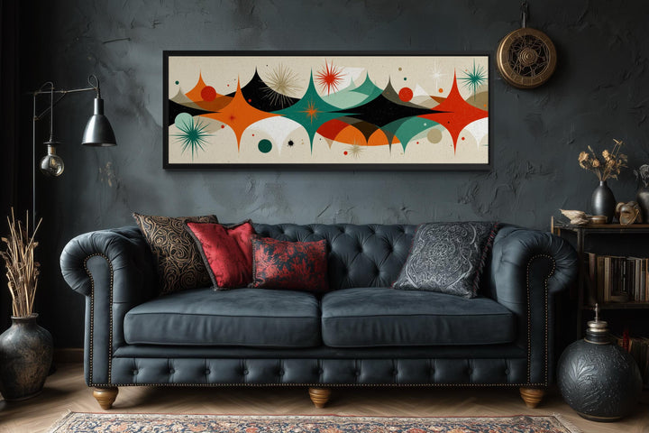 Mid Century Modern long horizontal canvas print with an atomic starburst design above a sofa.