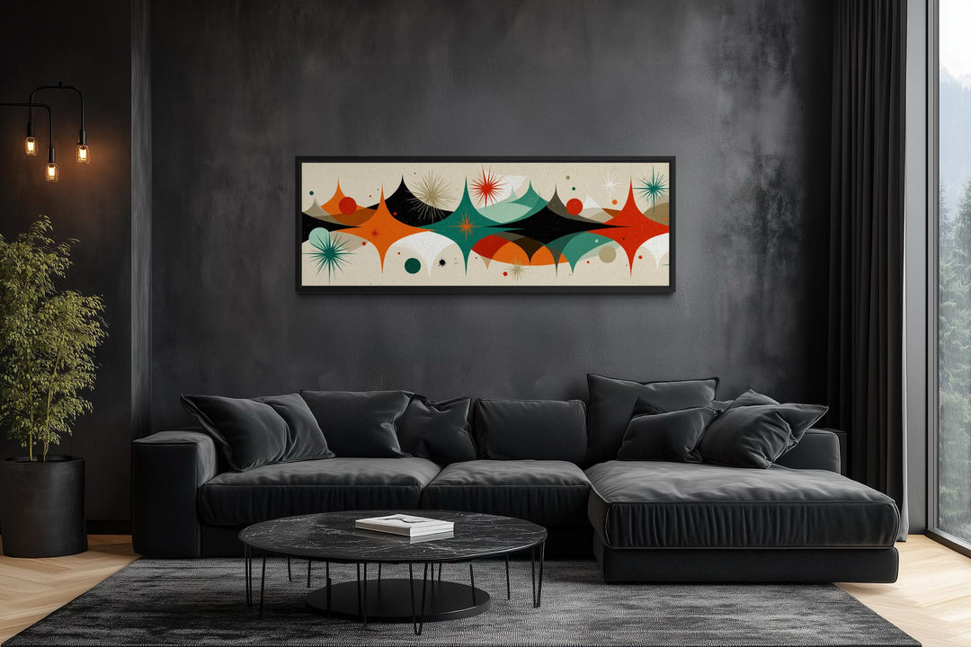 Mid century modern long horizontal canvas print with an atomic starburst design above a black sofa.