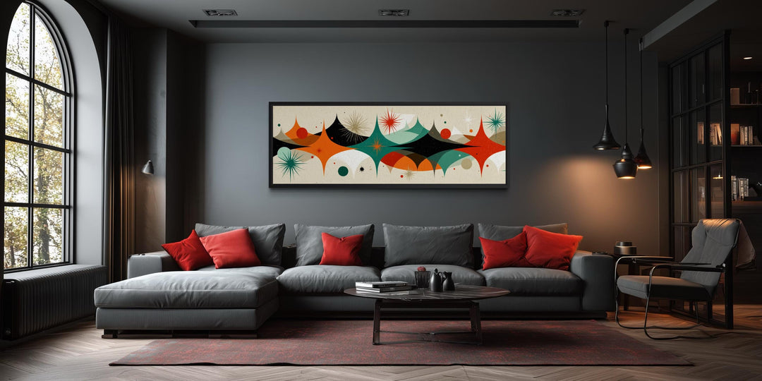Mid century modern long horizontal canvas print with an atomic starburst design above a gray sofa.